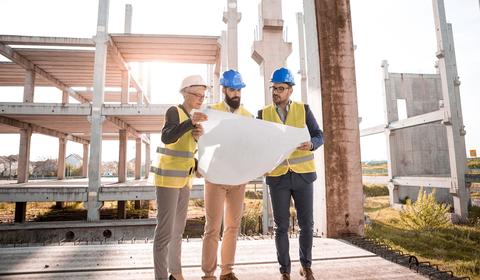 Three people reviewing plans at a client property site