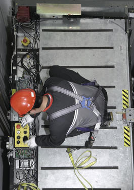 Looking down at someone in an elevator shaft while they conduct an elevator inspection