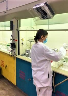 Two Laboratory employees at their stations, staying 6 feet apart