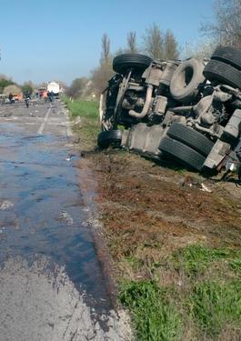 Truck overturned on the side of the road with first responders nearby