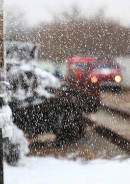 Blurred image of workers and first responders at a train track during snowfall