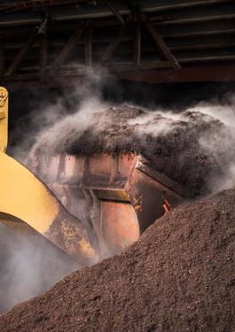 Truck lifting soil from a large pile
