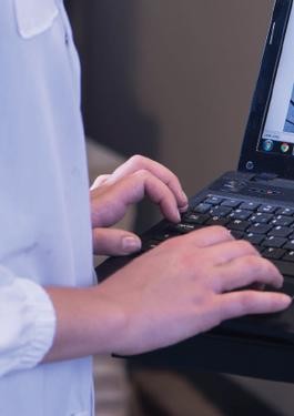 Lab technician typing on computer 