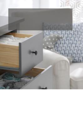 children's dresser with two drawers open and a white nursing chair