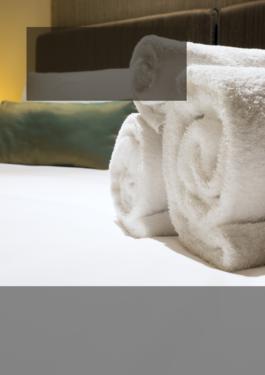 bath towels rolled up on a hotel bed