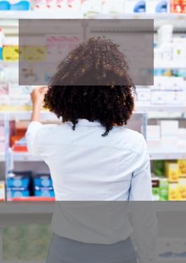 lady standing in a store in front of a shelf full of medications 