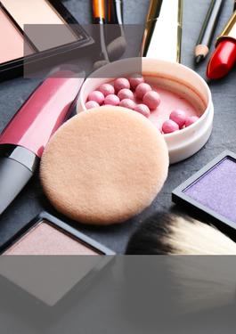 several makeup items scattered on a black surface