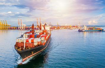 Colorful cargo ship sailing away from dock