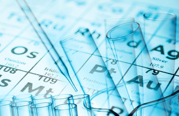 series of test tubes in front of the periodic table