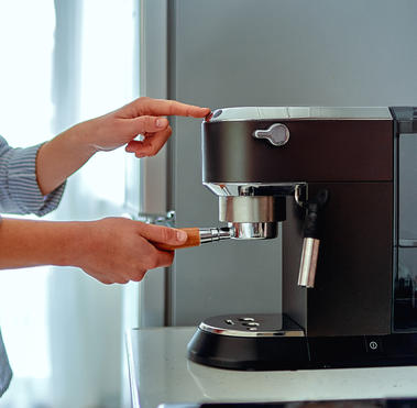 person using coffee maker